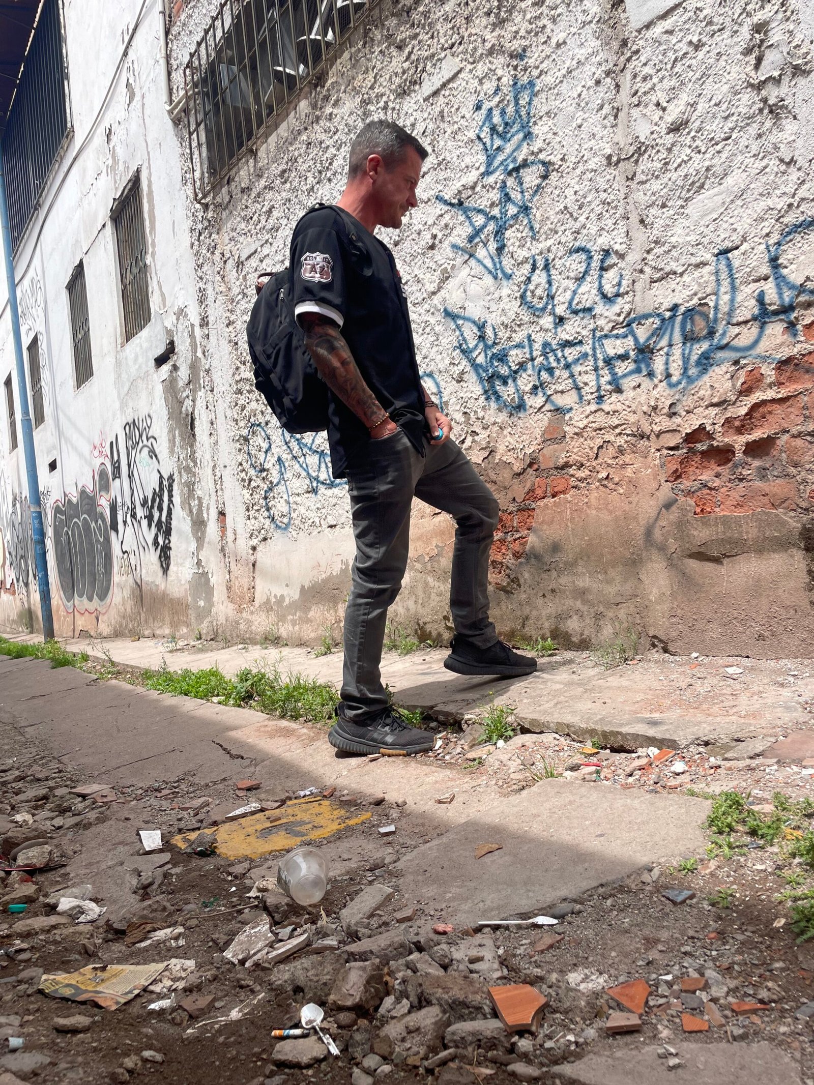 Man walking past graffiti-covered walls representing internal dialogue and mental conflict during addiction recovery.